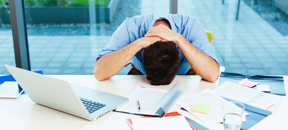 man with head in hands in office